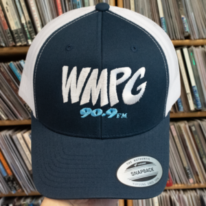 Picture of a navy blue snapback hat with white mesh in front of a CD rack.
