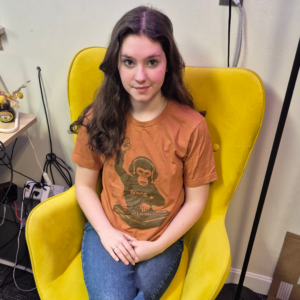 Picture of WMPG member modeling an orange t-shirt showing a monkey DJing.