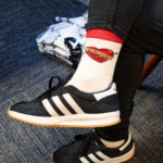 Picture of a WMPG member wearing a cream color sock with red accents. The design on the ankle is a heart with the line "WMPG has my heart" on it.